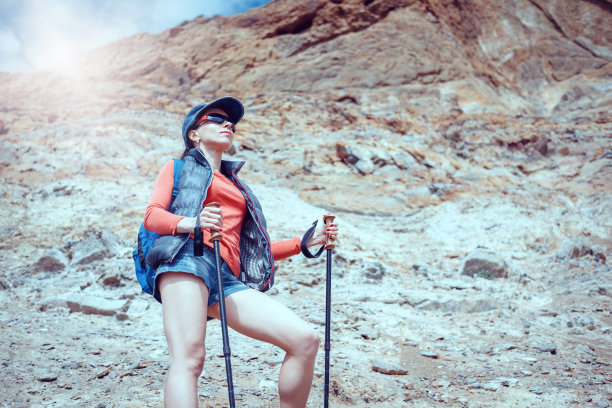 年轻的旅行者背着背包站在巨石上图片下载