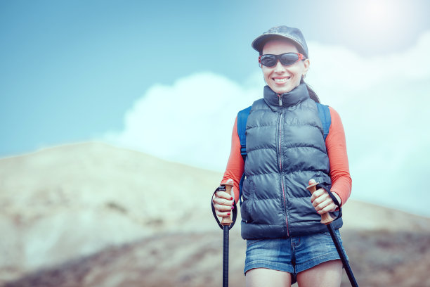 年轻的旅行者背着背包站在巨石上图片下载