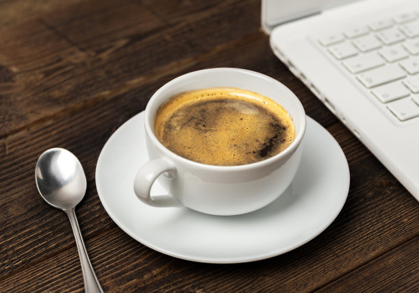 白色的咖啡杯和笔记本放在木桌上。图片下载