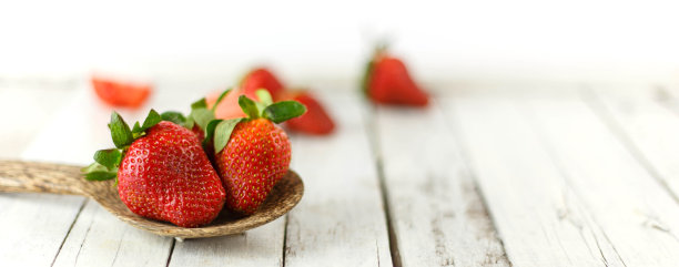新鲜的草莓放在木勺上图片下载