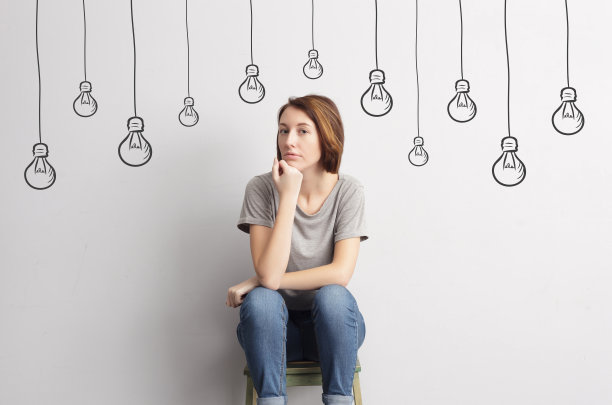 美丽苗条的女孩坐在凳子上，看起来很自信图片下载