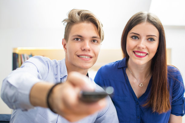 一对幸福的夫妇在客厅看电视。图片下载