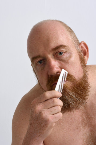 红发男子在白色背景上梳理胡须图片下载