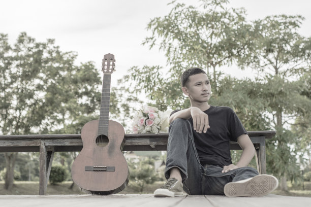 练习弹吉他。英俊的年轻人弹吉他图片下载