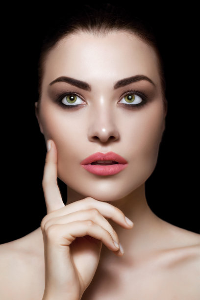 一个站在黑色背景下的美丽女人的肖像图片下载