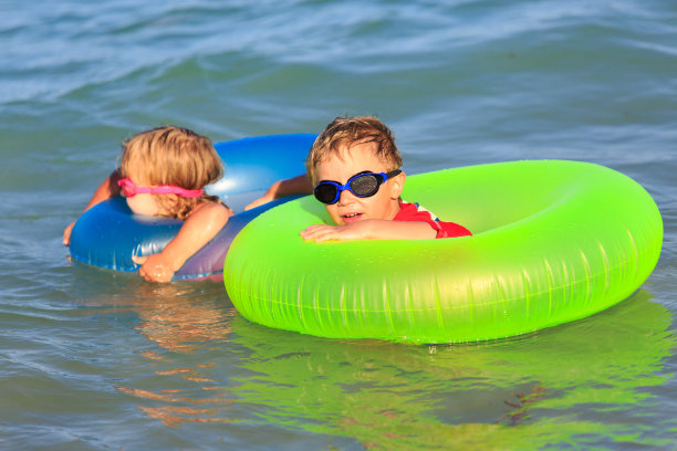 快乐的小男孩和小女孩在夏天的海滩游泳图片下载