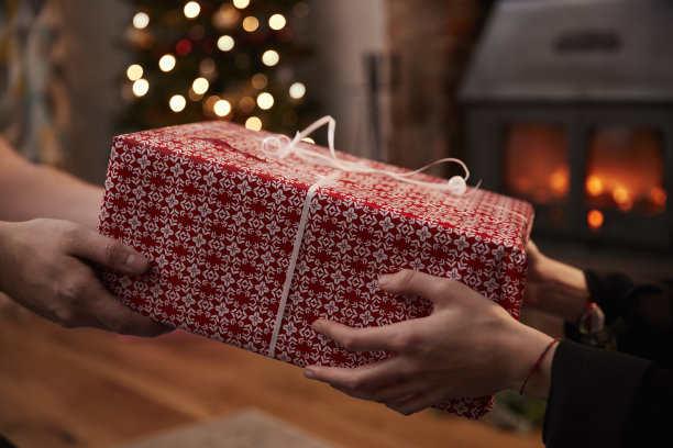 在为圣诞节装饰的房间里交换礼物的夫妇素材图片