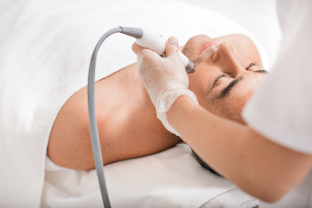 熟练的美容师进行超声波抗衰老程序图片下载