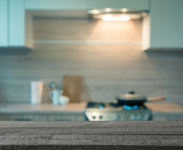 模糊的背景。用煤气做饭的现代厨房。健美的形象。图片下载