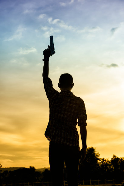 后面站着一个人的剪影，手握左轮手枪图片下载