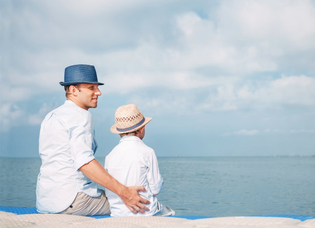 父亲和儿子一起坐在海边的码头上图片下载