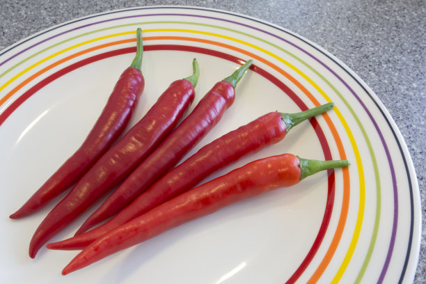 盘子里有四个红辣椒图片下载
