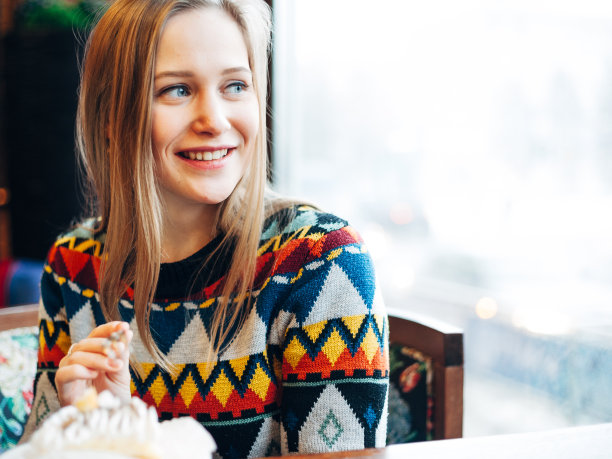 一个女人透过窗户喝果汁的照片图片下载