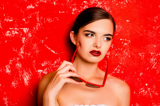 红背景下戴着眼镜的迷人女孩图片下载