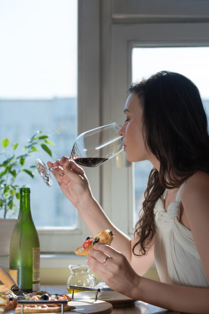 吃着自制披萨喝着红酒的女人图片下载