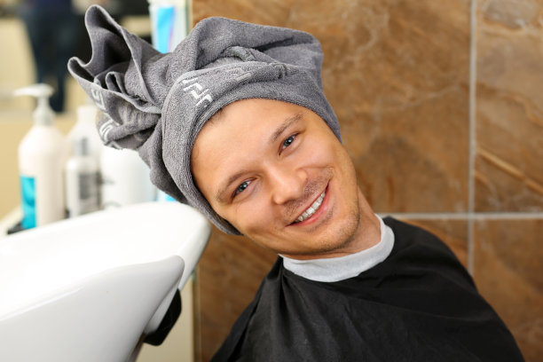 滑稽英俊的微笑男子的肖像与毛巾图片下载