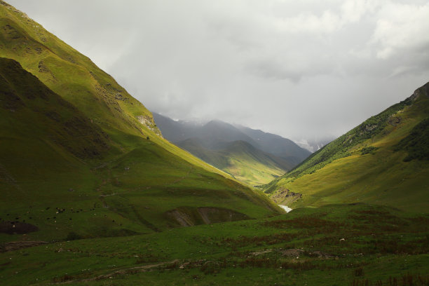 绿色高地景观与灰色云彩的图像图片下载
