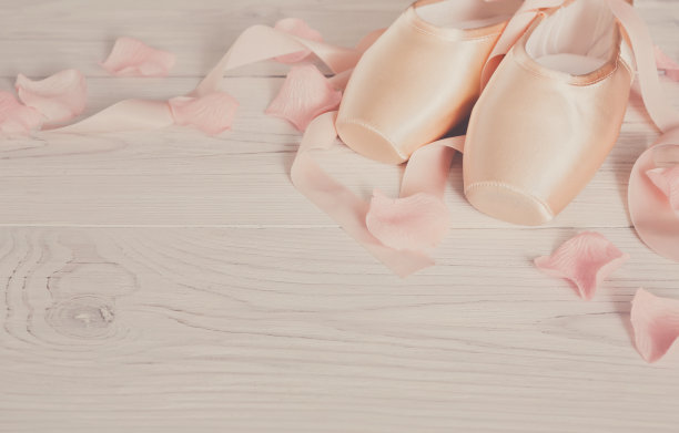 粉红色芭蕾舞尖头鞋在白色的木头背景图片下载
