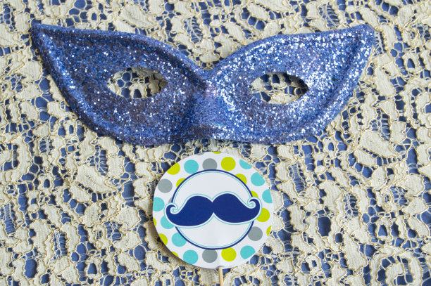 狂欢节上画着胡子的面具躺在蕾丝上图片下载