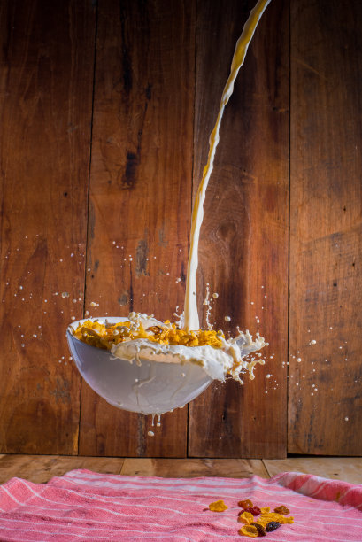 将牛奶倒入半空中的玉米片碗中图片下载