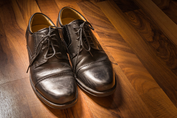 黑色皮鞋磨损木地板阳光聚光灯S图片下载