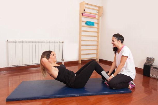 女孩在健身房的地板上做腹肌锻炼图片下载