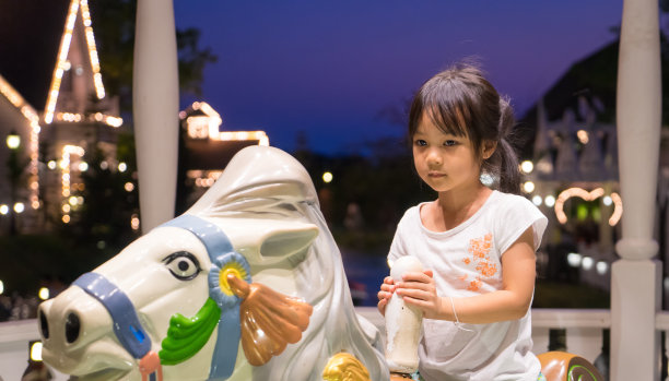 不快乐的亚洲女孩骑在房子里快乐地转。图片下载