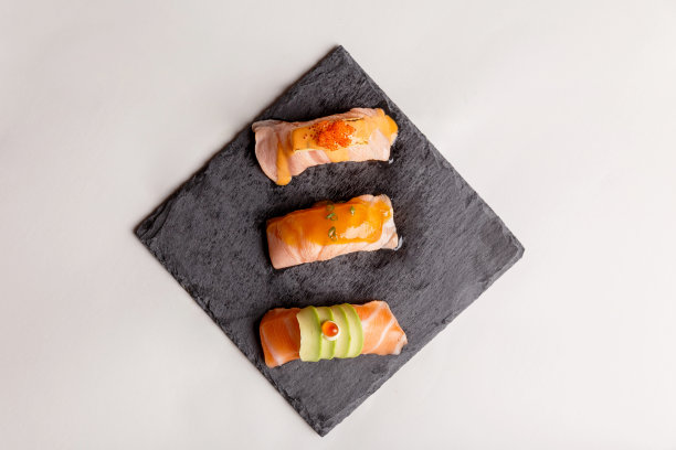 鲑鱼寿司在黑色的石头盘子。图片下载