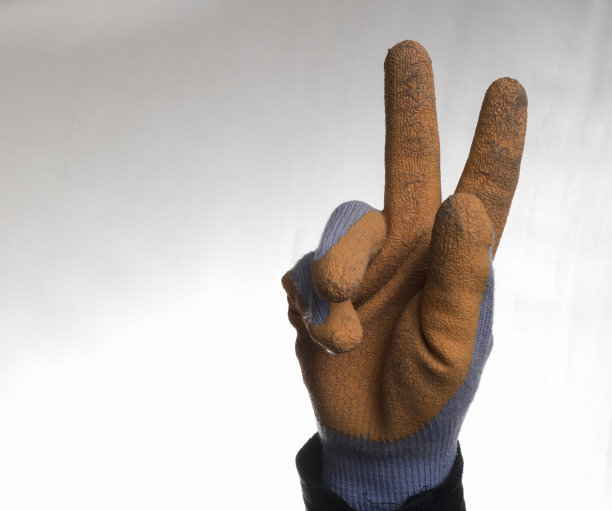 一个戴着手套的工人的胜利标志图片下载