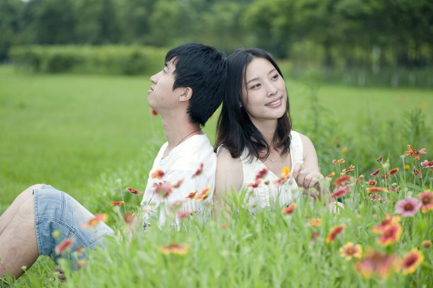 一对夫妇坐在花丛中微笑图片下载