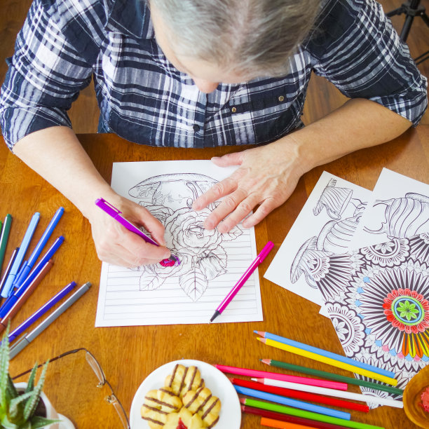 年长妇女的手拿着粉红色的马克笔给花上色图片下载