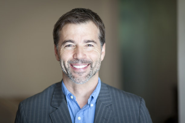 一个对着镜头微笑的成功商人的肖像图片下载