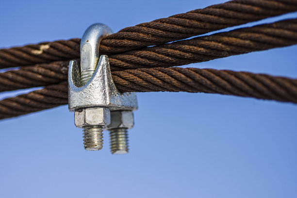 生锈的钢绳与闪亮的夹在蓝天的背景图片下载