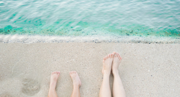 在海滩上伸展腿，清澈的水，大海图片下载