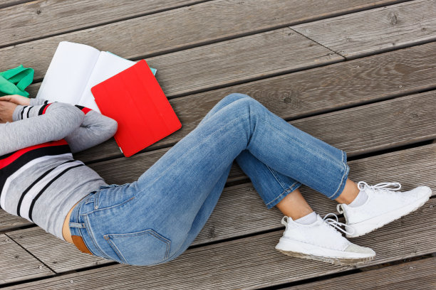 女孩在木制的舞台上打开书本睡着了图片下载
