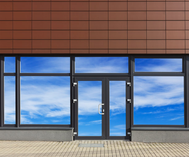 玻璃门窗映着天空的新无名办公室在现代化的量产建筑中。由几张照片拼贴而成。玻璃隔离贴片图片下载