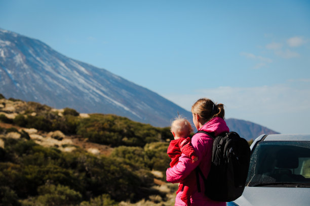 家庭旅行的汽车母亲与婴儿在山路上图片下载