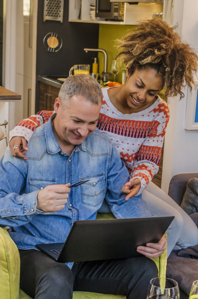 幸福的混血夫妇在家网上购物。图片下载