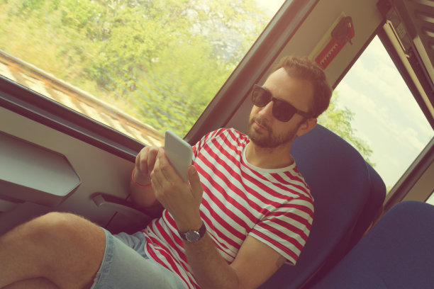 在火车上用手机的男人。图片下载