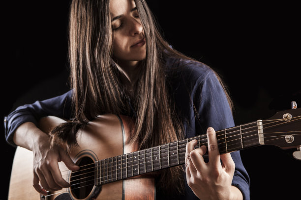 弹奏原声吉他的漂亮年轻女子图片下载