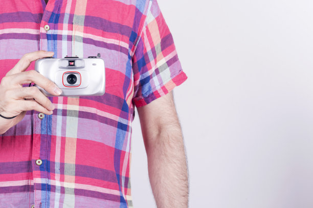 一个拿着旧胶卷相机的普通人。图片下载