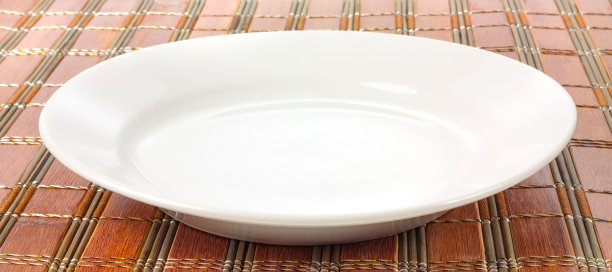 象征意义的白色盘子放在竹筐上图片下载
