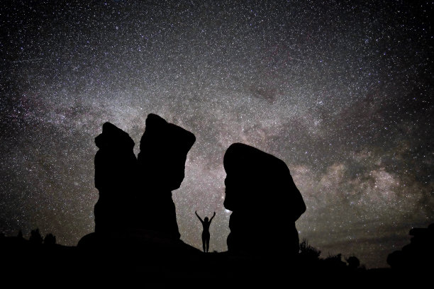 女人的剪影映衬着夜空，银河和星星。图片下载