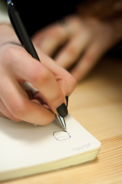 商业女性的纸，女性手写的笔记在桌子上黑色的美甲和空白的字母图片下载