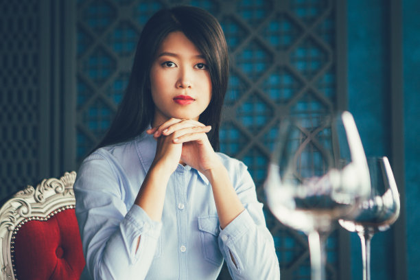 在餐馆里双手托着下巴的亚洲女人图片下载