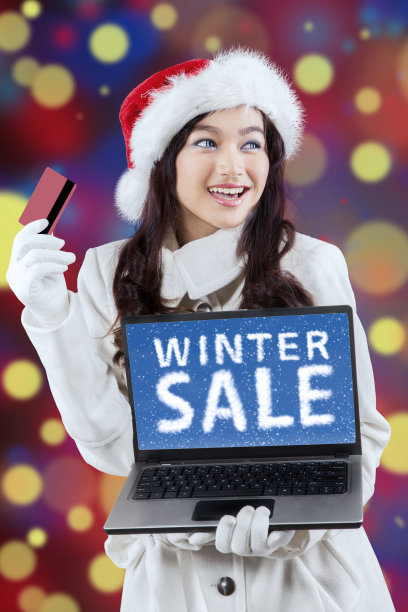 迷人的女孩在圣诞帽网上购物图片下载