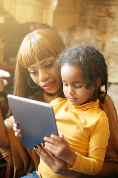 非洲母亲和女儿使用数字平板电脑。图片下载
