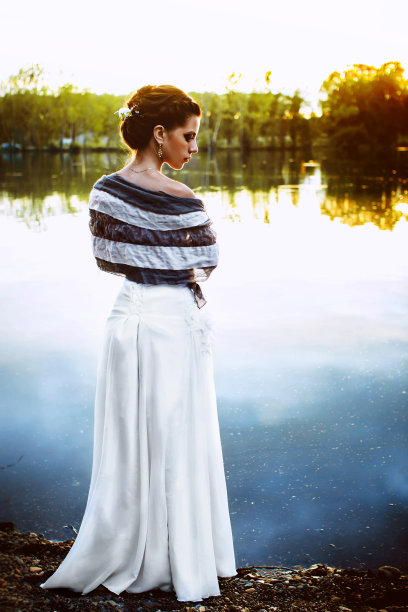 年轻美丽的女孩站在湖边，欣赏惊人的日落图片下载