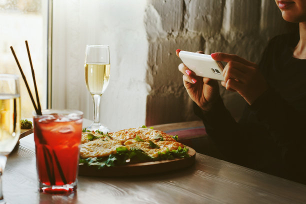 女孩在咖啡馆拍食物的照片。图片下载