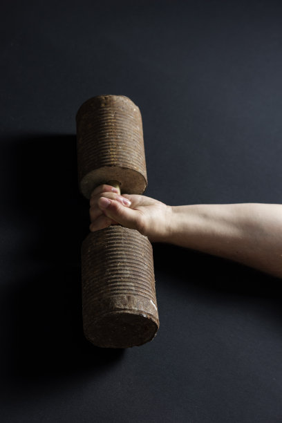 有力的手举起一个生锈的哑铃图片下载